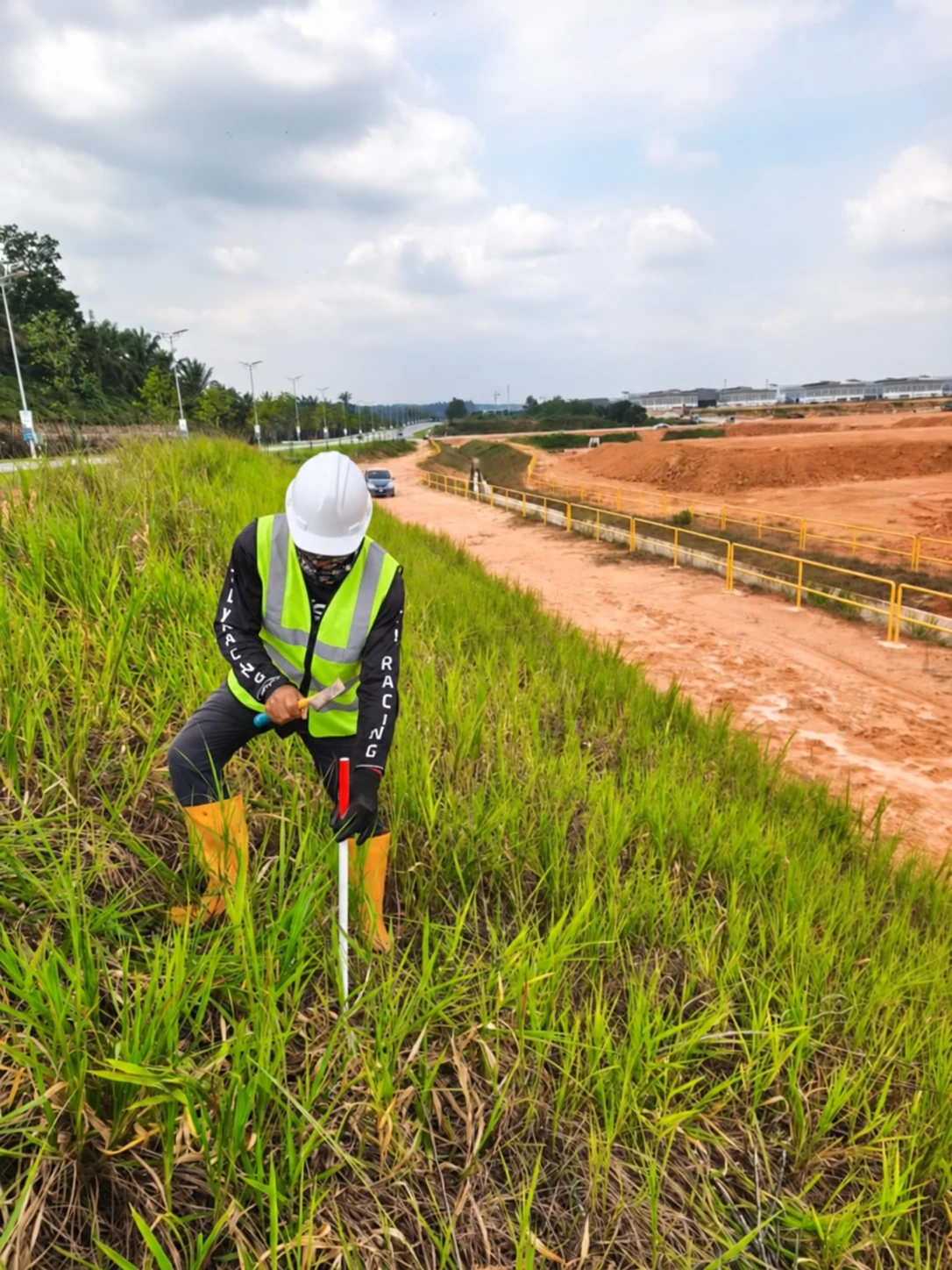 A survey worker placing a boundary reference peg in the field