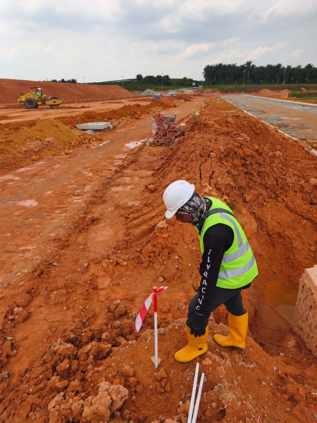 A survey worker setting out a reference point on a construction site